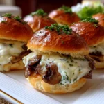 Freshly prepared mini mushroom Swiss sliders on white plate